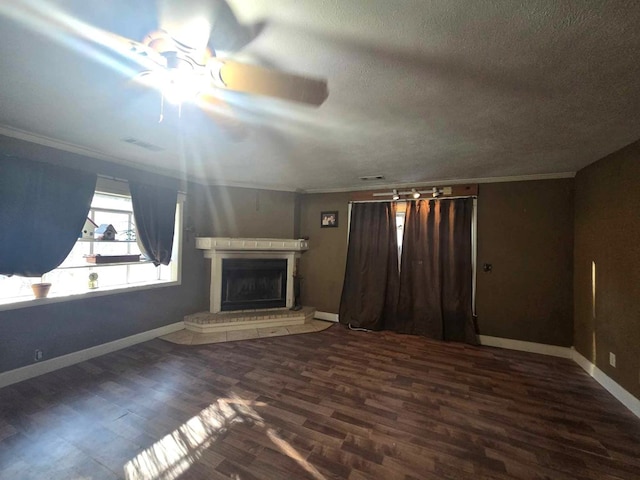 unfurnished living room with ceiling fan, a textured ceiling, dark wood-type flooring, and ornamental molding