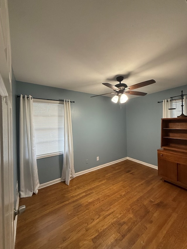 spare room with dark hardwood / wood-style floors and ceiling fan