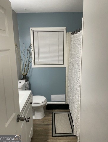 bathroom with vanity, toilet, and hardwood / wood-style floors