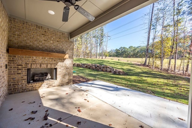 view of patio with an outdoor brick fireplace and ceiling fan