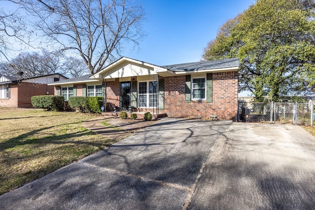 view of front of house with fence, brick siding, a front yard, and a gate