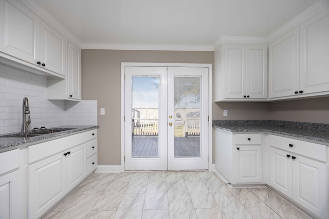 kitchen with ornamental molding, a sink, french doors, white cabinetry, and marble finish floor