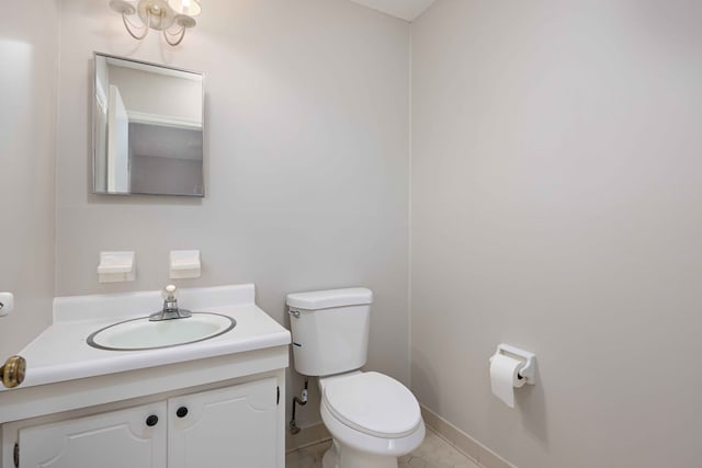 half bath with vanity, toilet, and baseboards