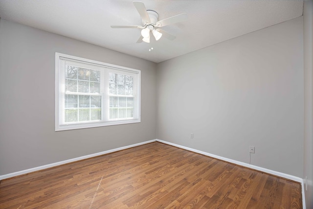 unfurnished room featuring ceiling fan, baseboards, and wood finished floors