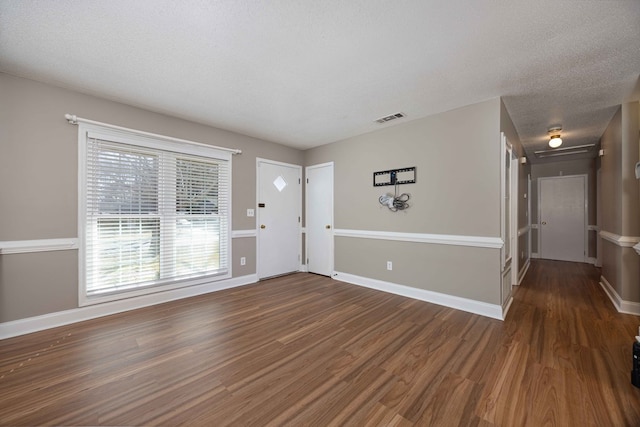 entrance foyer with visible vents, a textured ceiling, baseboards, and wood finished floors