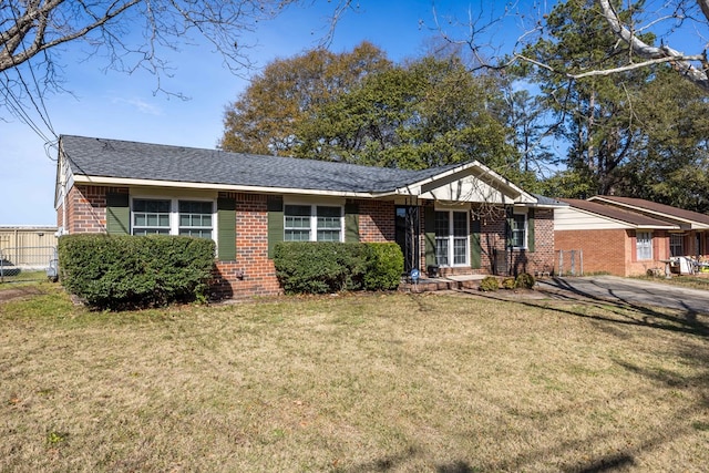 ranch-style home with brick siding, a front lawn, and fence