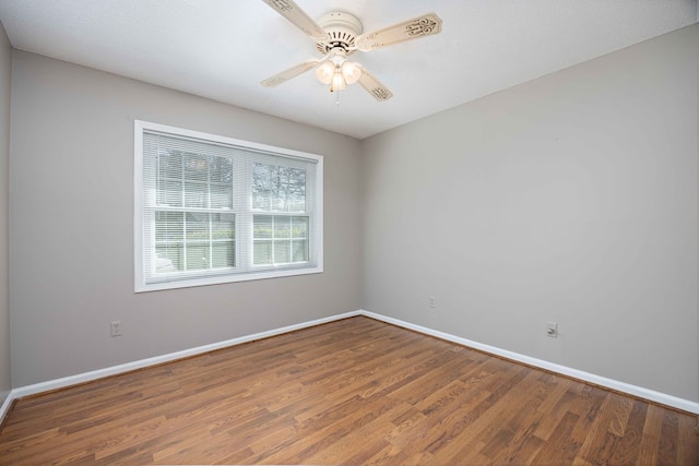 unfurnished room featuring baseboards, wood finished floors, and a ceiling fan