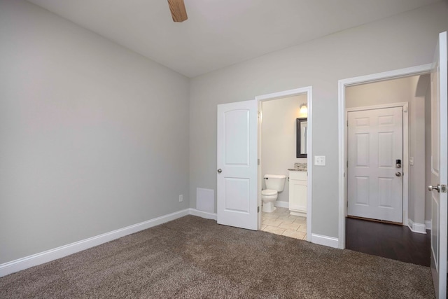 unfurnished bedroom with ensuite bathroom, ceiling fan, and light colored carpet