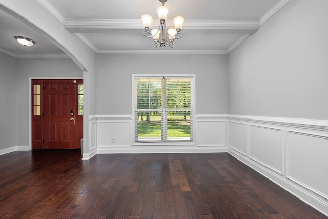 entrance foyer featuring a notable chandelier, ornamental molding, and dark wood-type flooring