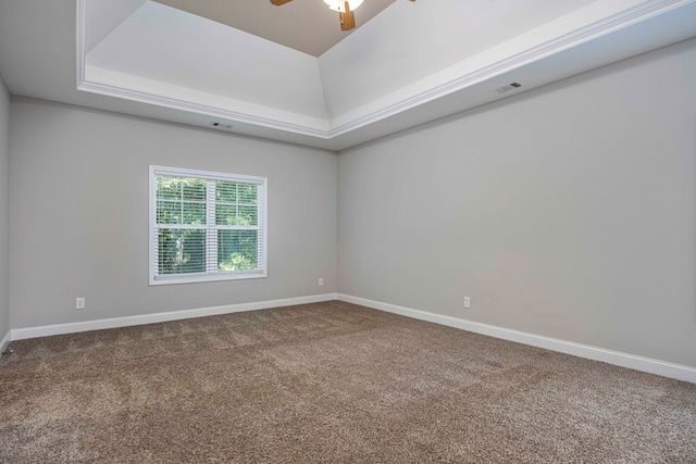 unfurnished room featuring a raised ceiling, ceiling fan, and carpet floors