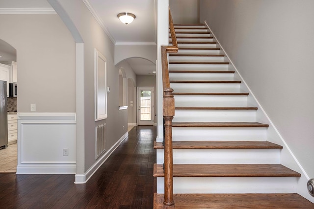 staircase with hardwood / wood-style flooring and crown molding