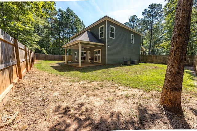 back of house with central air condition unit, ceiling fan, a yard, and a patio