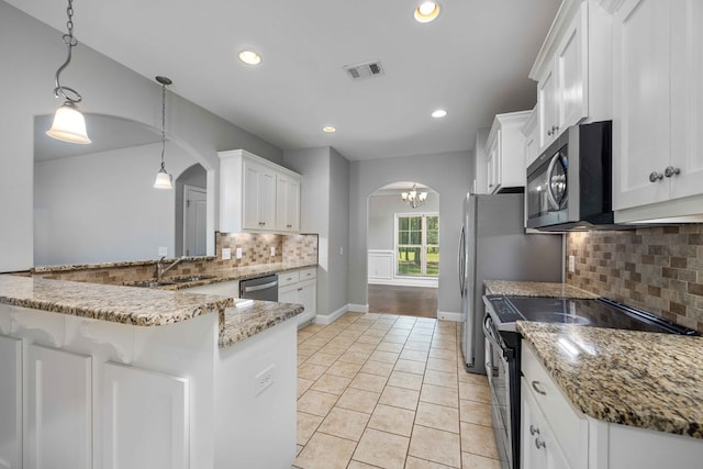 kitchen with kitchen peninsula, white cabinetry, hanging light fixtures, and stainless steel appliances