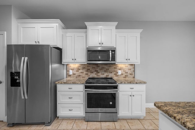 kitchen with appliances with stainless steel finishes, tasteful backsplash, white cabinetry, and dark stone counters