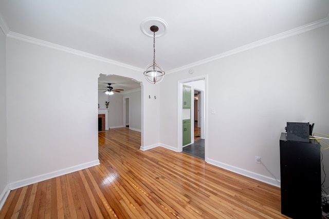 1729 41st St, Columbus, GA 31904 - unfurnished dining area featuring crown molding, light wood finished floors, baseboards, a ceiling fan, and a fireplace