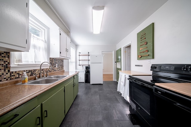 1729 41st St, Columbus, GA 31904 - kitchen with freestanding refrigerator, black / electric stove, green cabinets, a sink, and decorative backsplash