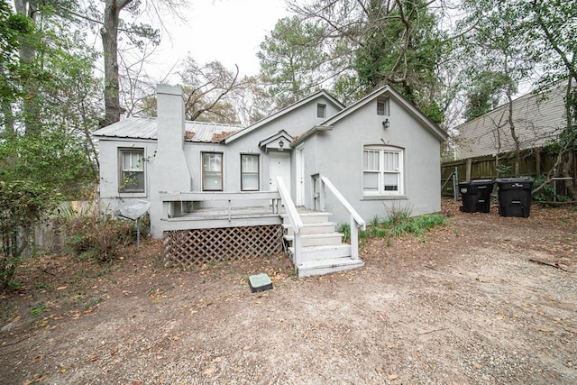 3515 Edgewood Rd, Columbus, GA 31907 - back of property featuring fence, a wooden deck, a chimney, stucco siding, and metal roof