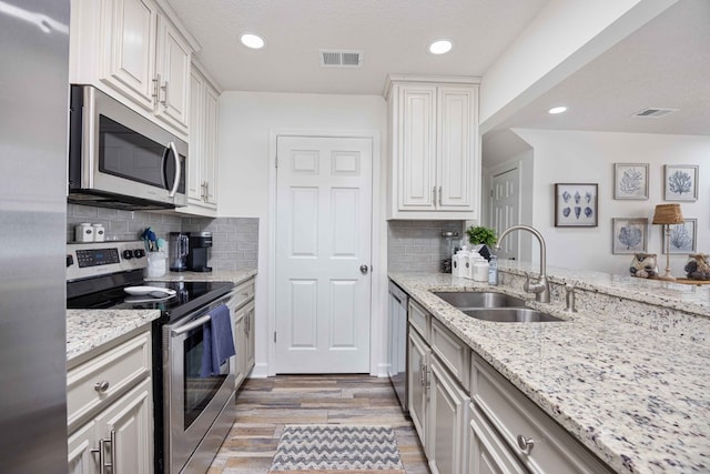 333 Eastside Dr Unit 4, Fortson, GA 31808 - kitchen featuring appliances with stainless steel finishes, light wood-style floors, visible vents, decorative backsplash, and a sink