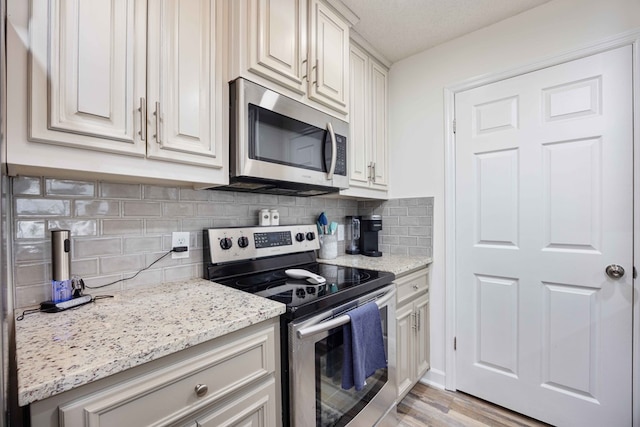 333 Eastside Dr Unit 4, Fortson, GA 31808 - kitchen with light wood-style floors, appliances with stainless steel finishes, light stone counters, and backsplash