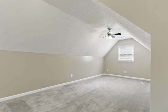 additional living space with lofted ceiling, carpet floors, baseboards, and ceiling fan