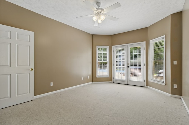 carpeted empty room with french doors, baseboards, a textured ceiling, and ceiling fan