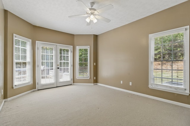 spare room with french doors, plenty of natural light, baseboards, a ceiling fan, and carpet floors