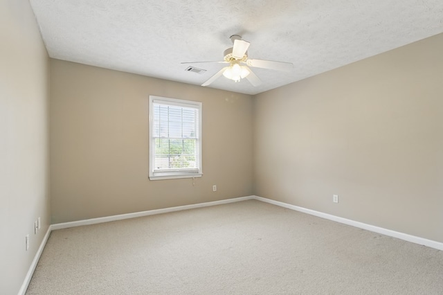 carpeted empty room featuring visible vents, baseboards, a textured ceiling, and ceiling fan