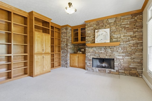 unfurnished living room with a stone fireplace, carpet floors, and crown molding