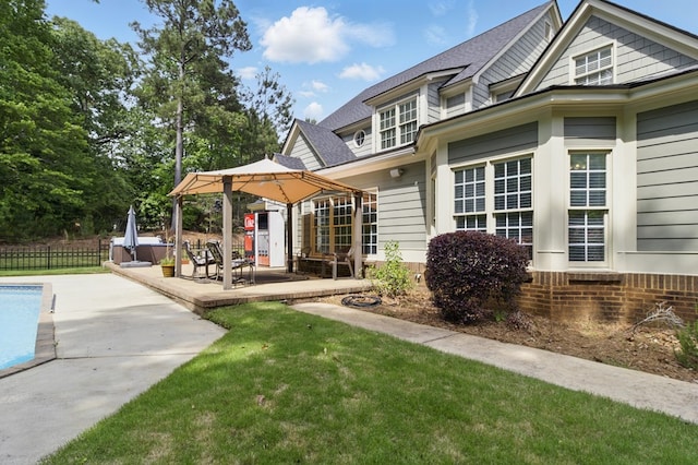 exterior space featuring a patio area, a lawn, fence, a fenced in pool, and roof with shingles