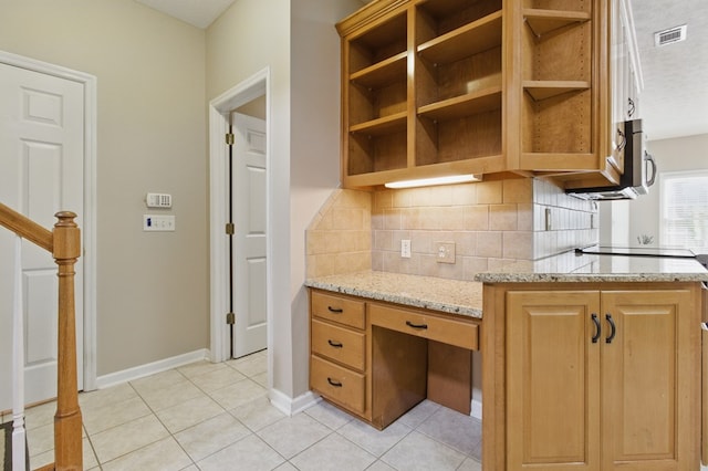 kitchen featuring open shelves, light tile patterned flooring, light stone countertops, and decorative backsplash