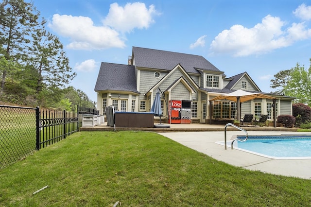 back of house featuring a jacuzzi, a patio area, fence, a yard, and a fenced in pool