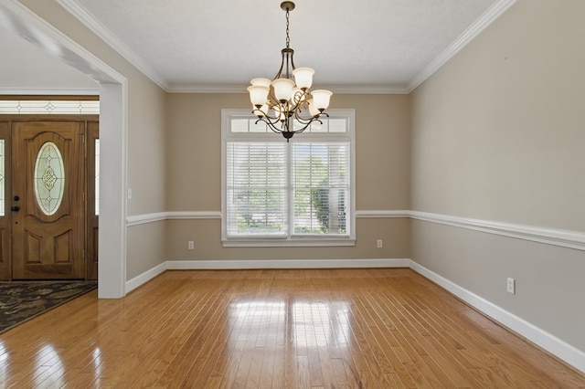foyer entrance with light wood-style flooring, baseboards, a notable chandelier, and crown molding