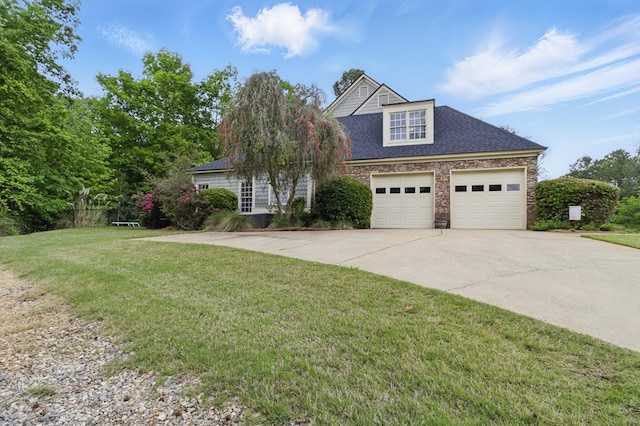 view of front of house featuring driveway, stone siding, an attached garage, a front yard, and roof with shingles