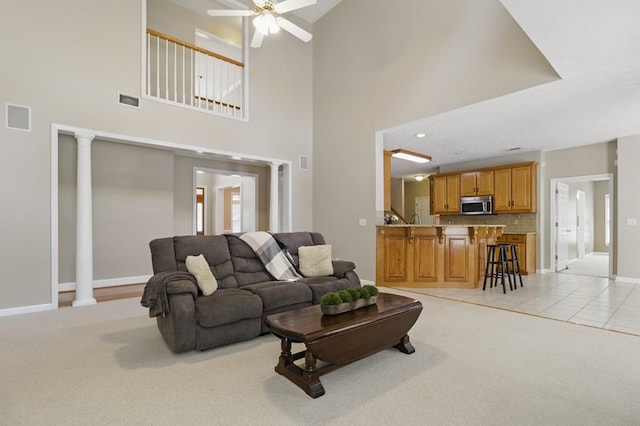 living room with light colored carpet, ceiling fan, and visible vents