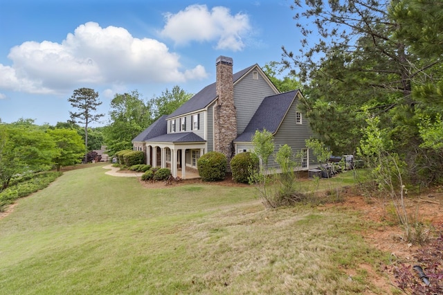 view of side of property featuring a chimney and a yard