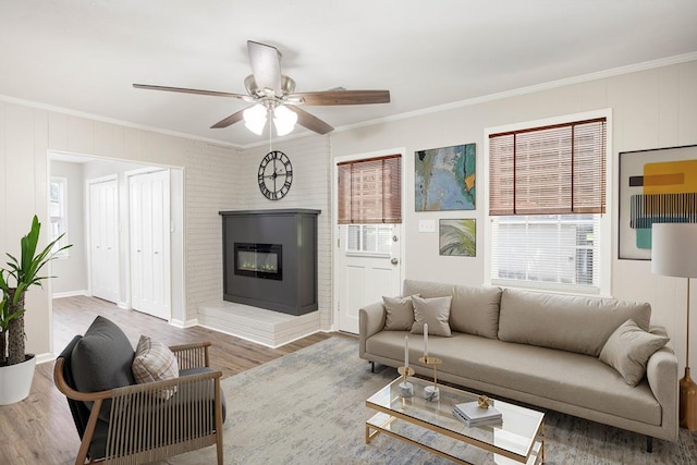 8085 Ga Highway 0219, Hamilton, GA 31811 - living room with ornamental molding, healthy amount of natural light, a glass covered fireplace, ceiling fan, and wood finished floors