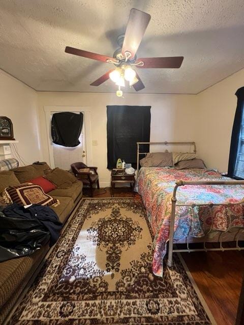 bedroom featuring ceiling fan, hardwood / wood-style floors, and a textured ceiling