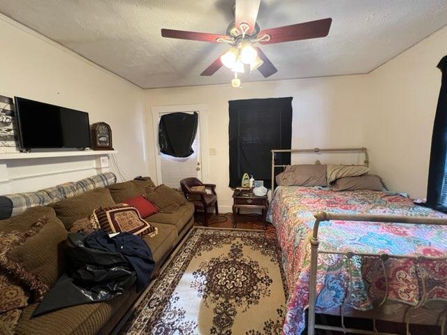 bedroom with wood-type flooring, a textured ceiling, and ceiling fan