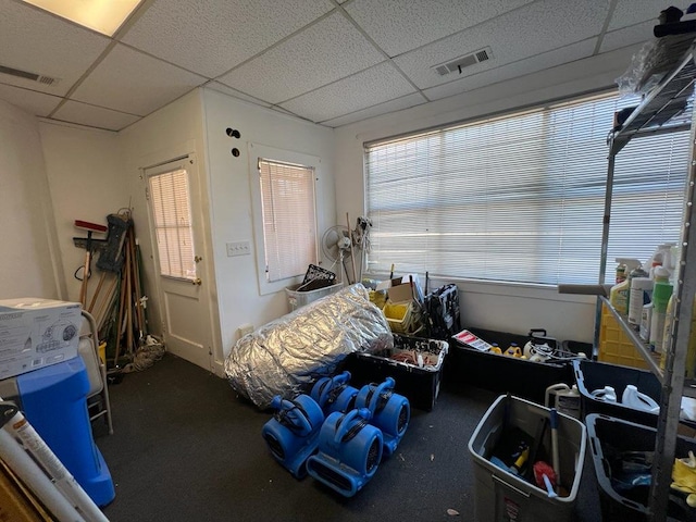 interior space with a drop ceiling and dark carpet