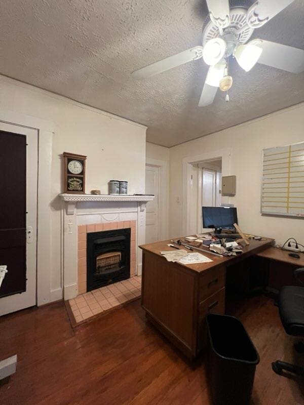 office area with ceiling fan, dark hardwood / wood-style flooring, and a textured ceiling