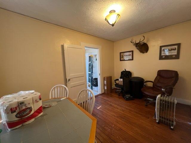 dining space featuring a textured ceiling and hardwood / wood-style flooring