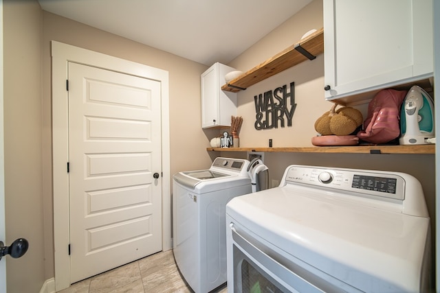 washroom featuring cabinets and washing machine and dryer