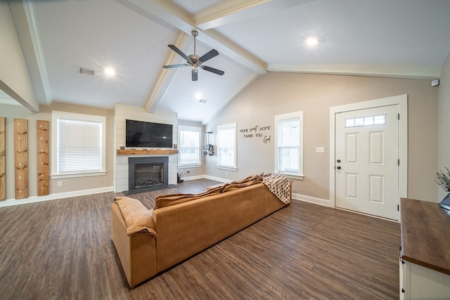 living room with dark wood-type flooring, ceiling fan, a fireplace, and lofted ceiling with beams