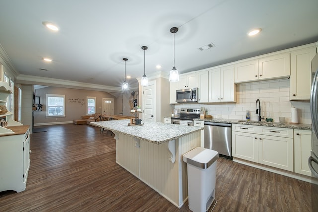 kitchen featuring dark hardwood / wood-style floors, decorative light fixtures, white cabinets, a center island, and stainless steel appliances