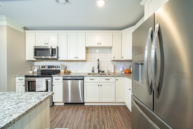 kitchen with white cabinetry, sink, stainless steel appliances, and light stone countertops