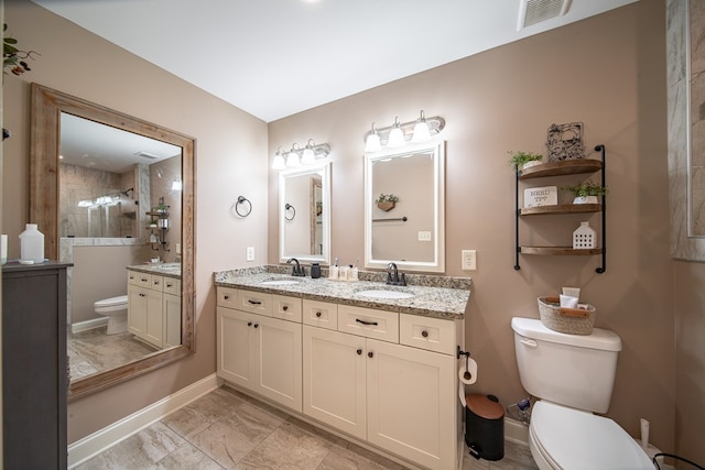 bathroom with vanity, toilet, and tiled shower