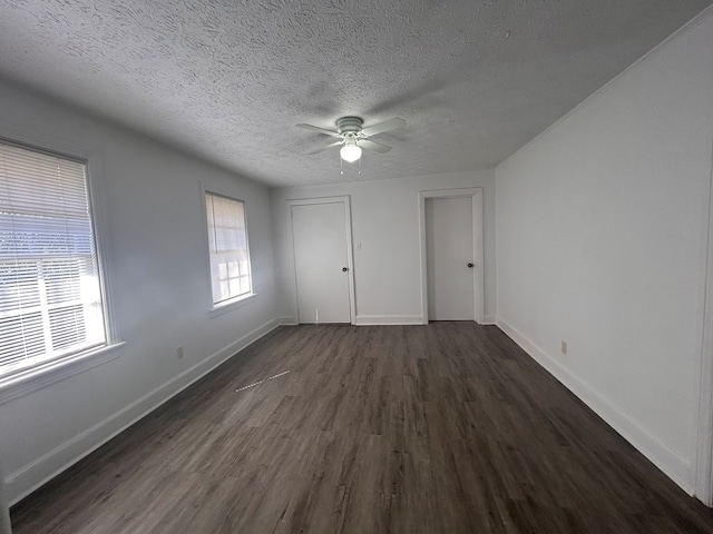 unfurnished bedroom with ceiling fan, dark wood-type flooring, a closet, and a textured ceiling