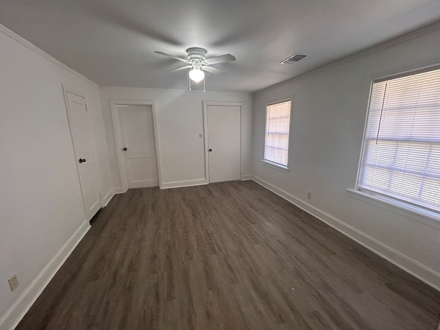 interior space with crown molding, ceiling fan, and dark hardwood / wood-style floors