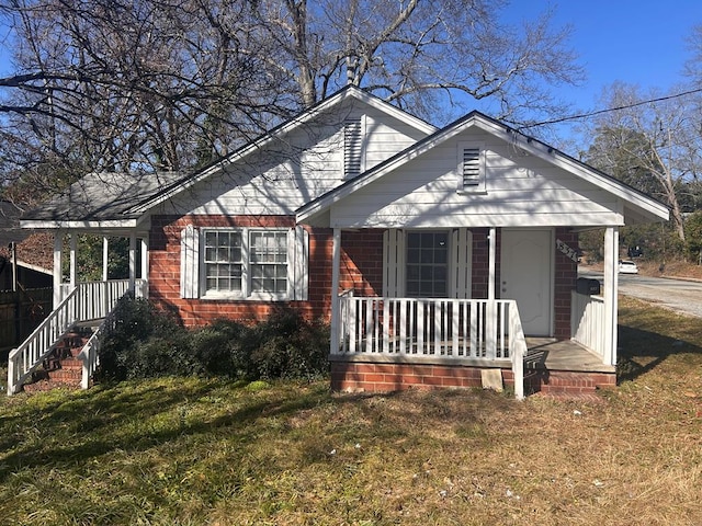 view of front of property with a porch and a front yard