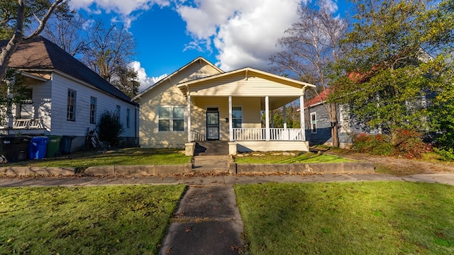 bungalow featuring covered porch and a front lawn